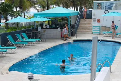 two people in the swimming pool at a resort at Marenas LATERAL ocean view daily refresh not included Fees collected at arrival in Sunny Isles Beach