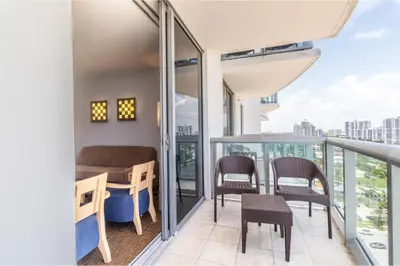 a balcony with chairs and a table on top of a building at Marenas LATERAL ocean view daily refresh not included Fees collected at arrival in Sunny Isles Beach