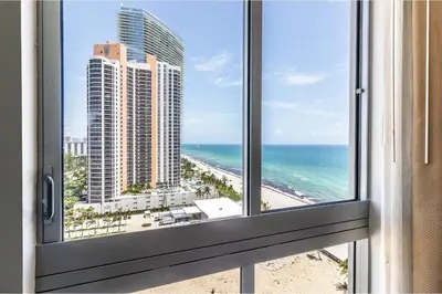 a window with a view of the beach and ocean at Marenas LATERAL ocean view daily refresh not included Fees collected at arrival in Sunny Isles Beach