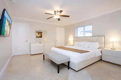 a white bedroom with a bed and a ceiling fan at Ultimate Luxury 5BR Villa near Hollywood Beach in Hollywood