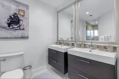 a bathroom with two sinks and a toilet and a mirror at Ocean House in Dania Beach