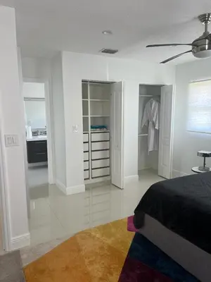 a white bedroom with a bed and a closet at Ocean House in Dania Beach