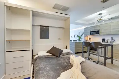 a bedroom with a large bed and a kitchen at High-End Miami Condo with City and Bay Views!!! in Miami