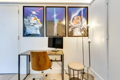 a room with a desk with a computer and three pictures on the wall at High-End Miami Condo with City and Bay Views!!! in Miami