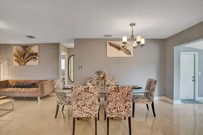 a dining room with a table and chairs and a couch at Luxury 3bd/2ba near Beach & Las Olas in Fort Lauderdale