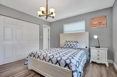 a bedroom with a bed and a chandelier at Luxury 3bd/2ba near Beach & Las Olas in Fort Lauderdale