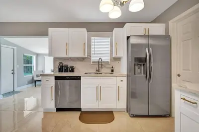 a kitchen with white cabinets and a stainless steel refrigerator at Luxury 3bd/2ba near Beach & Las Olas in Fort Lauderdale