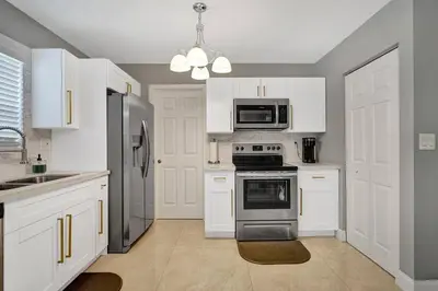 a kitchen with white cabinets and stainless steel appliances at Luxury 3bd/2ba near Beach & Las Olas in Fort Lauderdale