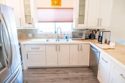 a kitchen with white cabinets and a sink at 5 min to airport and 15 min to beach! in Fort Lauderdale