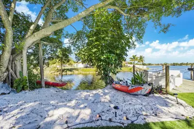 a couple of boats sitting on the sand under a tree at Dior Lake Front Villa With Infinity Pool in Miami Gardens