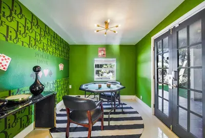 a dining room with green walls and a table and chairs at Dior Lake Front Villa With Infinity Pool in Miami Gardens