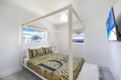 a bedroom with a canopy bed in a white room at Dior Lake Front Villa With Infinity Pool in Miami Gardens
