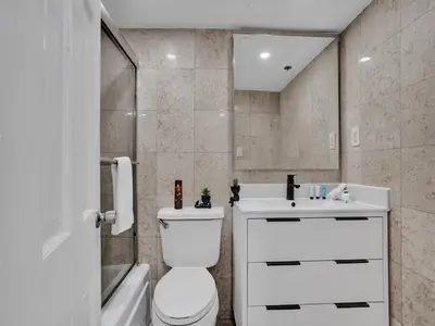 a bathroom with a toilet and a sink and a tub at Oceanfront Haven Retreat Beach Service 502 in Miami Beach