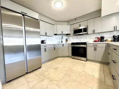 a kitchen with white cabinets and stainless steel appliances at Oceanfront Haven Retreat Beach Service 502 in Miami Beach