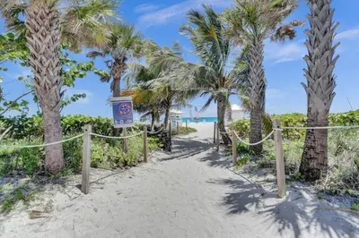 a path leading to the beach with palm trees at Beachfront Condo w Beach Service 1207 in Miami Beach