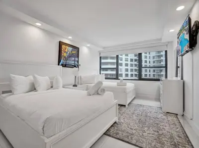 a white bedroom with a large bed and a large window at Amazing Ocean View Condo Beach Service 1111 in Miami Beach