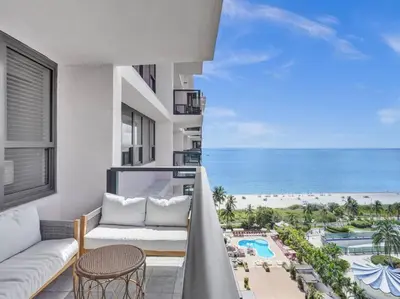a balcony with a view of the beach and the ocean at High Floor Beachfront Condo Beach Service 1509 in Miami Beach