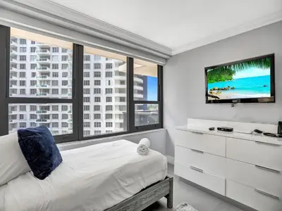 a bedroom with a bed and a large window at Amazing 3BD Ocean View Condo Beach Service 715 in Miami Beach