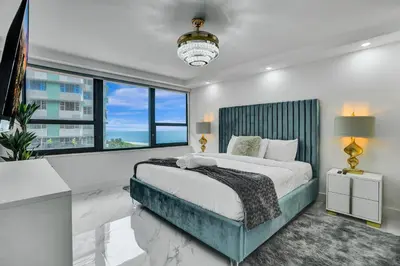 a bedroom with a large bed and a large window at Cozy Ocean View Condo Beach Service and Pool 808 in Miami Beach