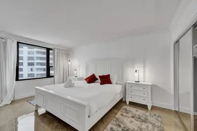 a white bedroom with a white bed and a window at Cozy Ocean View Condo Beach Service 1015 in Miami Beach