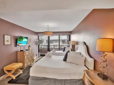 a bedroom with a large white bed and a television at Ocean View Condo Beach Service and Pool 618 in Miami Beach