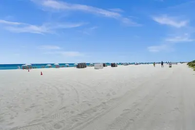 a beach with people walking on the sand at Spacious Ocean View Condo Beach Service 803 in Miami Beach