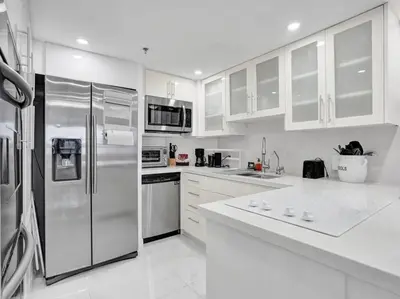 a kitchen with white cabinets and stainless steel appliances at Luxury Beachfront Condo Beach Service 1418 in Miami Beach