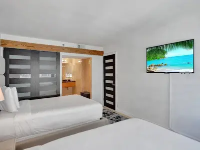 a bedroom with two beds and a television on the wall at Luxury Ocean View Condo Beach and Resort 1216 in Miami Beach