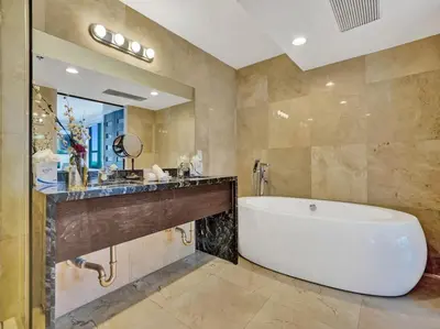 a bathroom with a tub and a large mirror at Luxury Full Ocean View Condo Resort Amenities 501 in Miami Beach