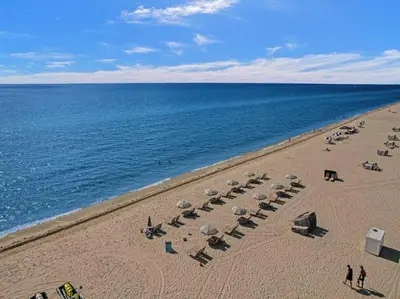 a beach with chairs and umbrellas and the ocean at Luxury Full Ocean View Condo Resort Amenities 501 in Miami Beach