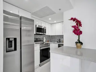a kitchen with a stainless steel refrigerator and a vase of flowers at Ocean View Retreat Beach Service 1603 in Miami Beach