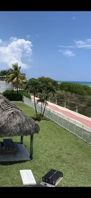a resort with a grass roof and a fence at Pavilion in Miami Beach