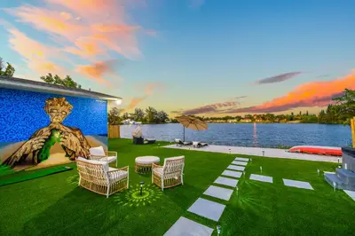 a yard with chairs and a wall with a painting at Tulum Villa in Miami