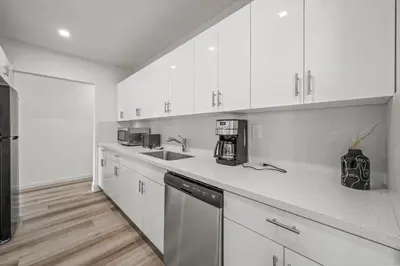 a kitchen with white cabinets and a counter top at Tulum Villa in Miami