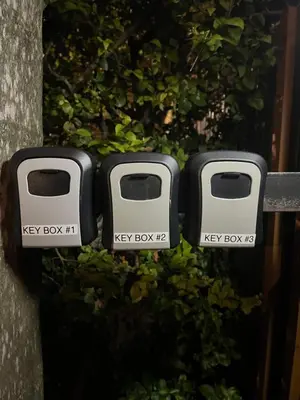 two parking meters sitting on top of a fence at Luna y Sol Calle 8 in Miami
