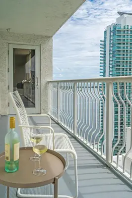 a glass of wine on a table on a balcony at LUX 2B/2B Brickell - Free Parking in Miami