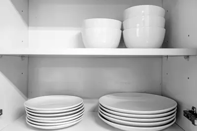 two plates and bowls on a shelf in a kitchen at LUX 2B/2B Brickell - Free Parking in Miami