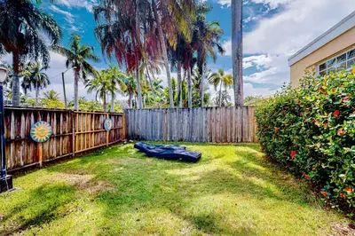 a mattress laying on the grass in a yard next to a fence at Go with the Flow in Hollywood