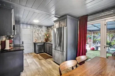 a kitchen with a stainless steel refrigerator and a table at Kiki Grand Suite - Men's Clothing optional Guest Houses in Fort Lauderdale