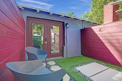 a patio with two chairs and a red door at Kiki 1 - Men's Clothing optional Guest Houses in Fort Lauderdale