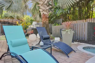 a group of blue chairs sitting next to a pool at Kiki 3 - Men's Clothing optional Guest Houses in Fort Lauderdale