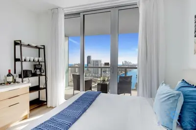a bedroom with a bed and a large window at Infinite View Balcony Gym Amaizing Pool in Hallandale Beach