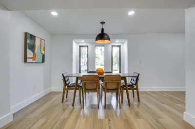 a dining room with a wooden table and chairs at Chic Florida Retreat with Pool, Patio and Gas Grill! in Fort Lauderdale