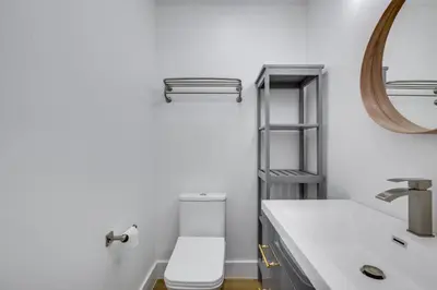 a bathroom with a white toilet and a mirror at Chic Florida Retreat with Pool, Patio and Gas Grill! in Fort Lauderdale