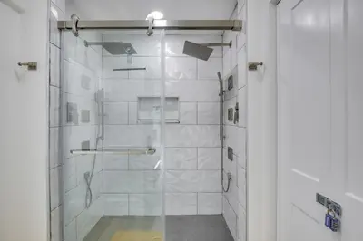 a bathroom with a shower with a glass door at Chic Florida Retreat with Pool, Patio and Gas Grill! in Fort Lauderdale