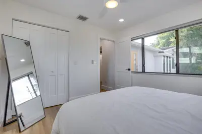 a bedroom with a white bed and a large window at Chic Florida Retreat with Pool, Patio and Gas Grill! in Fort Lauderdale