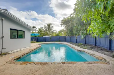a swimming pool in a yard next to a house at Chic Florida Retreat with Pool, Patio and Gas Grill! in Fort Lauderdale