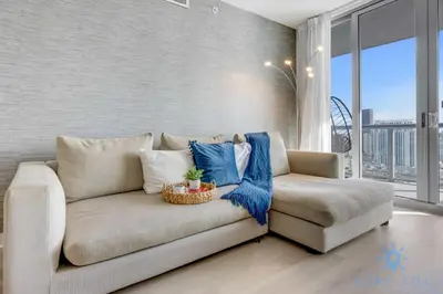 a living room with a couch and a chair at Amaizing Pool Infinity View w Balcony Gym in Hallandale Beach