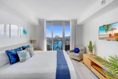 a bedroom with a large bed and a large window at Amaizing Pool Infinity View w Balcony Gym in Hallandale Beach