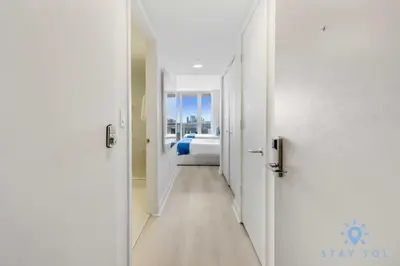 a hallway leading to a bedroom with a bed at Upper studio w Balcony Pool Gym Near Beach in Hallandale Beach